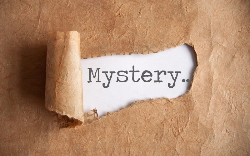 The word Mystery revealed behind a torn chunk of paper.