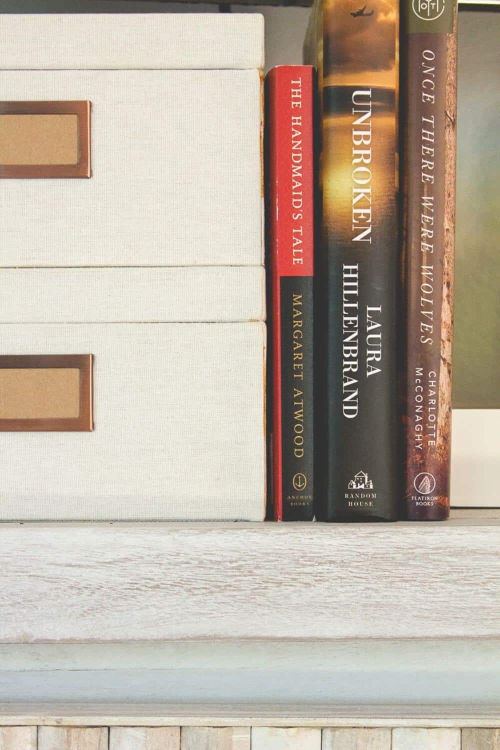 The Handmaid's Tale, Unbroken, and Once There Were Wolves, some of my favorite books, on a shelf